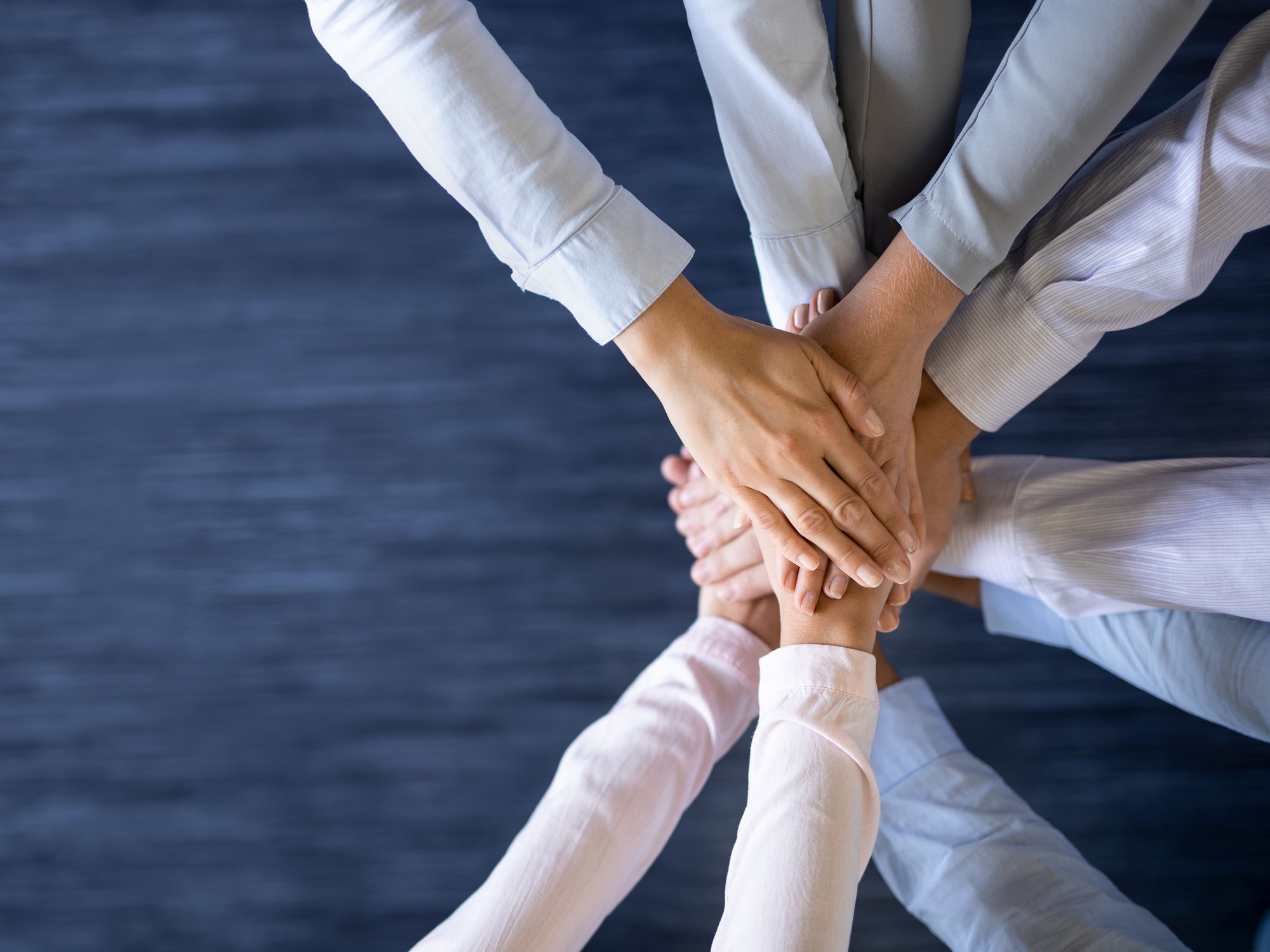 Mains r&eacute;unies au centre d&rsquo;un groupe, en signe de collaboration